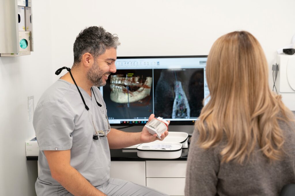 Cardo visar en implantatmodell under ett samtal på XDental i Norrköping